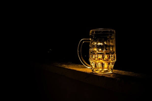 kufel z piwem podświetlony na czarnym tle