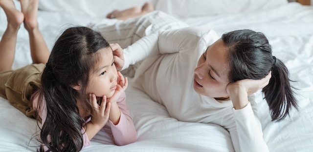 Mama z córką leżące na łóżku