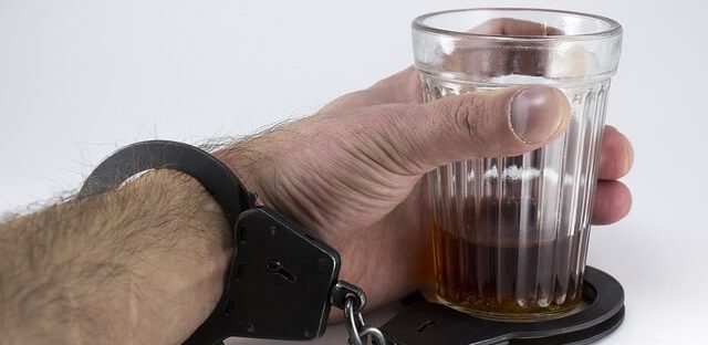 Mężczyzna przykuty kajdankami do szklanki